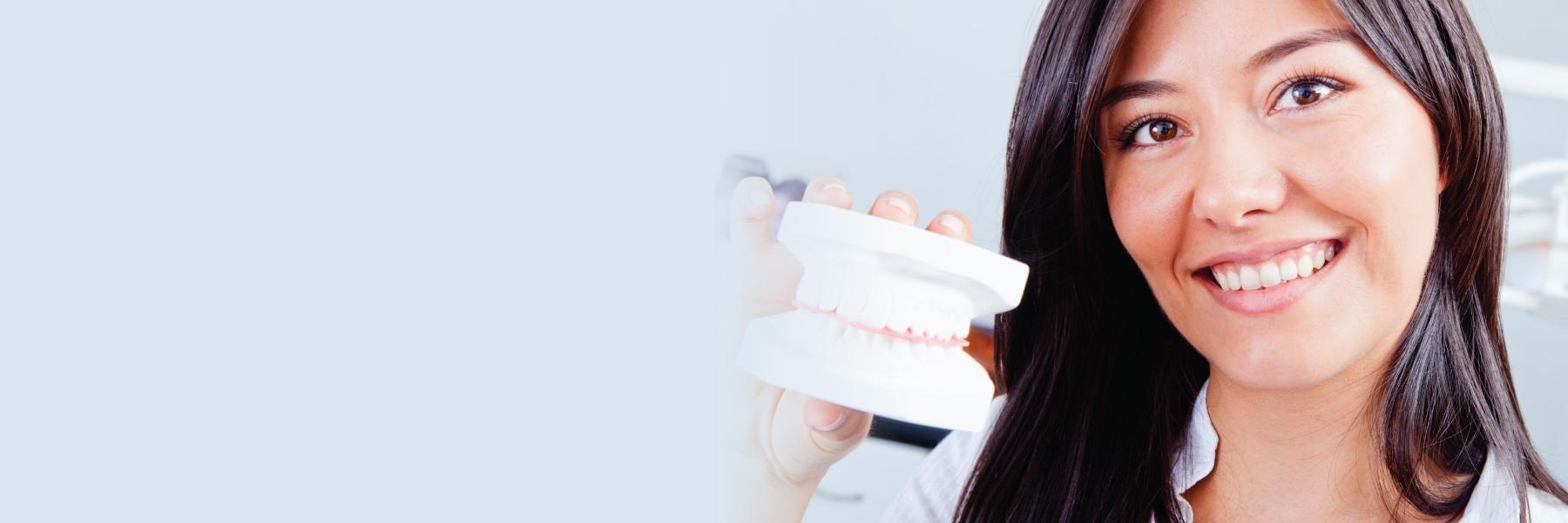 Patient holding model of teeth at dental office in Bonita Springs