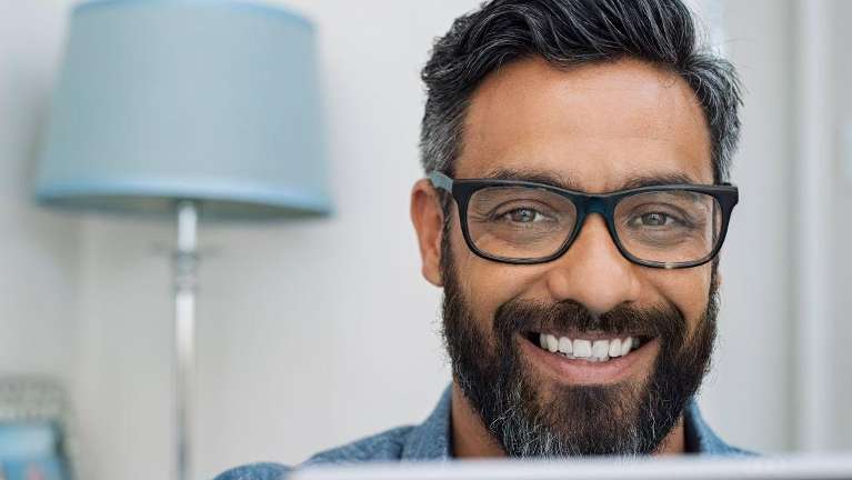 man smiling with his implant supported dentures in bonita springs
