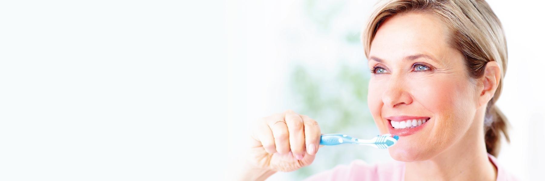 Woman brushing her teeth at dentist office in Bonita Springs FL