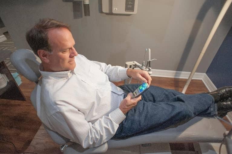 Patient using remote controlled massage chair at dentist in Bonita Springs