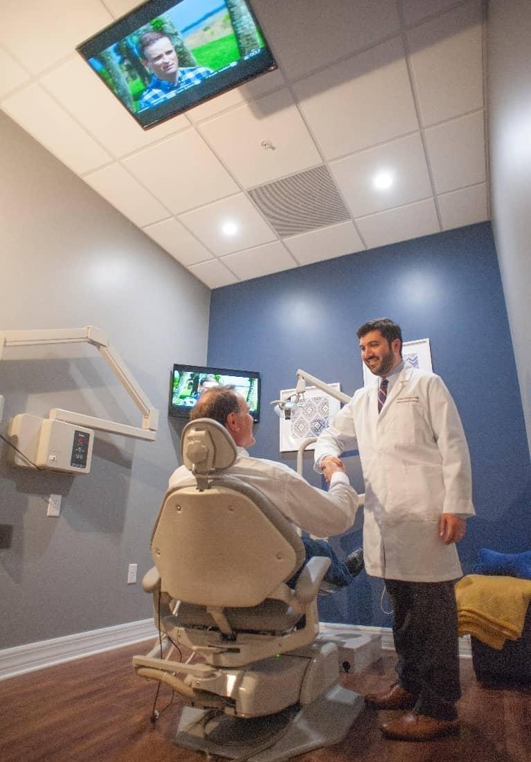 Dentist in Bonita Springs shaking hands with patient in treatment chair